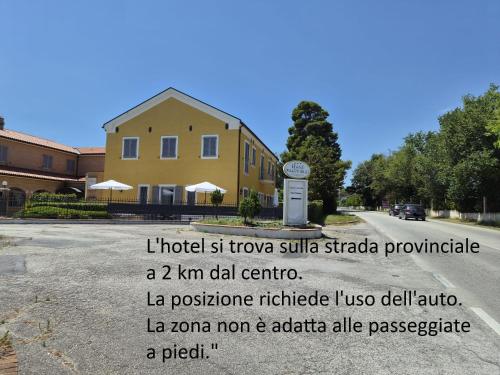 a building with a sign in the middle of a road at Hotel Palazzo Bello in Recanati
