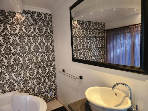 a bathroom with a sink and a mirror at Villa Mexicana Guesthouse in Kimberley