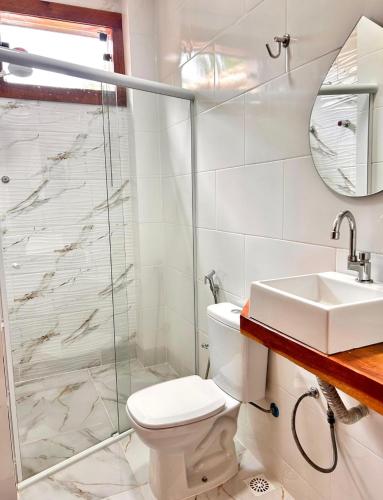 a bathroom with a toilet and a sink and a shower at Pousada Real Cipo in Serra do Cipo