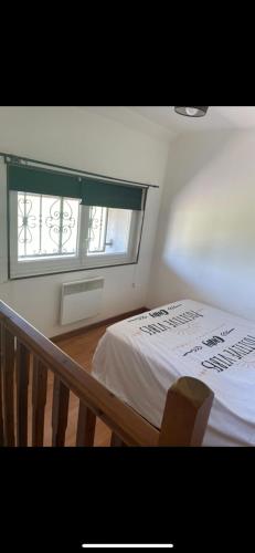 a bedroom with a bed and a window at Le Climatisé Old School in Paroy-sur-Tholon
