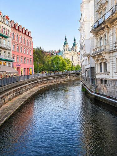 a river in the middle of a city with buildings at Colonnade Studio, Karlovy Vary in Karlovy Vary