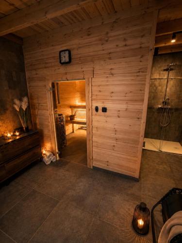 a wooden room with a door and a room with a tub at Chatička in Veľká Lomnica
