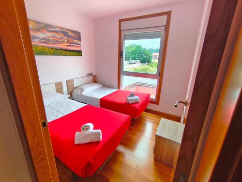 a small room with two beds and a window at Apartamentos Illa de Arousa 3000 in Isla de Arosa