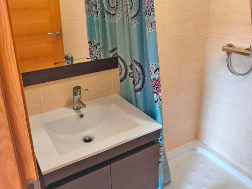 a bathroom with a sink and a shower curtain at Apartamentos Illa de Arousa 3000 in Isla de Arosa
