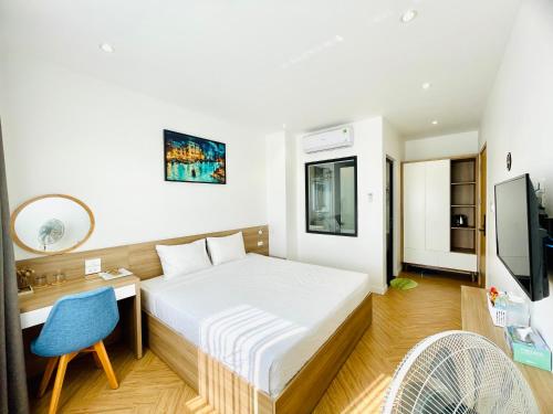 a bedroom with a bed and a desk and a chair at The Track Homestay - Near Bai Dai Beach in Cam Lâm