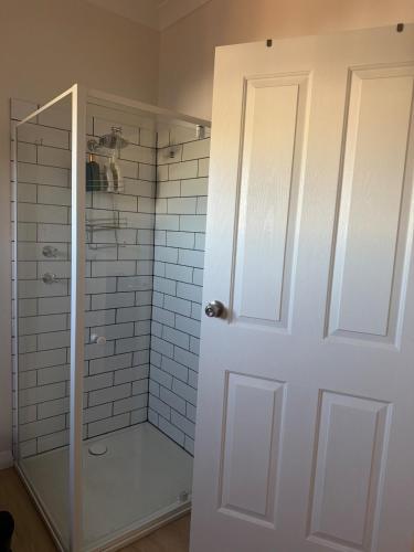 a bathroom with a shower with a glass door at Lamington Guesthouse in Kalgoorlie