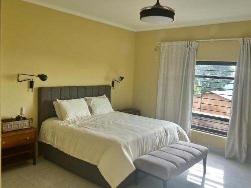 a bedroom with a large bed and a window at The Cozy Nook in Blantyre