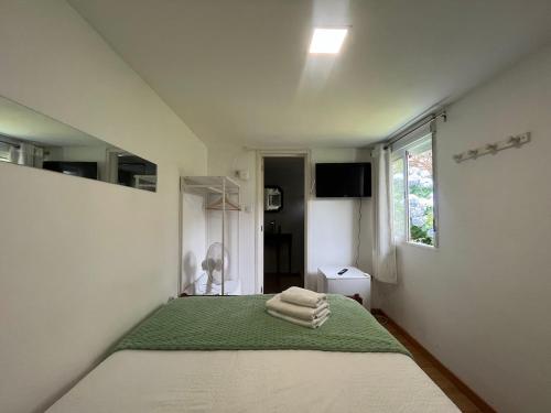 a bedroom with a bed with towels on it at Hostel das Flores in Senhora da Hora