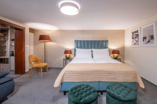 a bedroom with a large bed with a blue headboard at Zámecký hotel & Wellness in Poděbrady