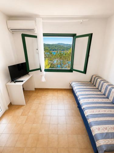 a living room with a couch and a window at Povlja Bungalows in Povlja