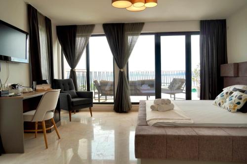 a bedroom with a large bed and a desk and chairs at Marina Sarafovo by Cosher in Burgas