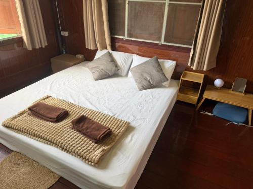 a bedroom with a bed with a towel on it at taitoon hostel&cafe in Chiang Rai