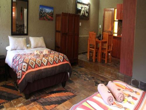 a bedroom with a bed and a table and chairs at Emahlathini Guest Farm in Piet Retief
