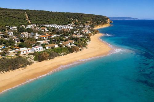 an aerial view of a beach with houses and the ocean at Kampaoh Los Caños in Los Caños de Meca