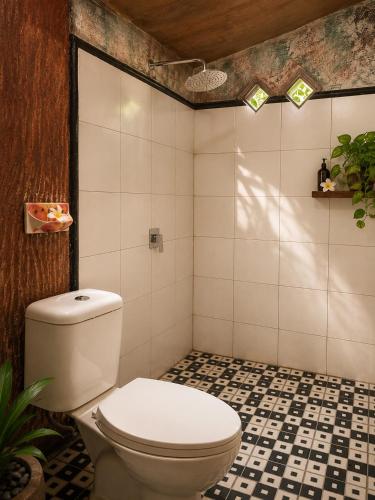 a bathroom with a toilet and a tile floor at Tetebatu Garden Lombok in Tetebatu