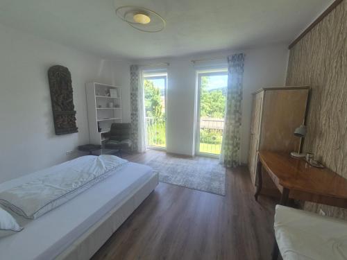a bedroom with a bed and a desk and a window at Dein Zuhause am See in Millstatt
