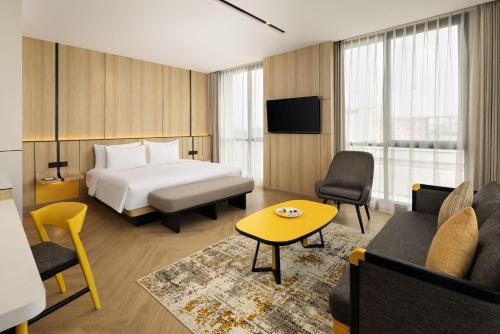 a hotel room with a bed and a couch at Kampi Hotel Sunter in Jakarta