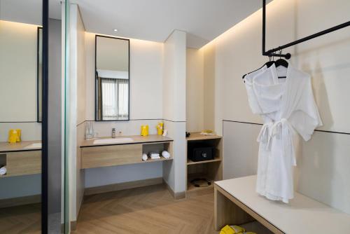 a bathroom with a white robe hanging on a wall at Kampi Hotel Sunter in Jakarta