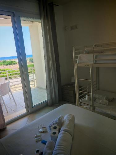 a bedroom with a bed and a view of a balcony at Sea Rooms - Torre Pali in Torre Pali