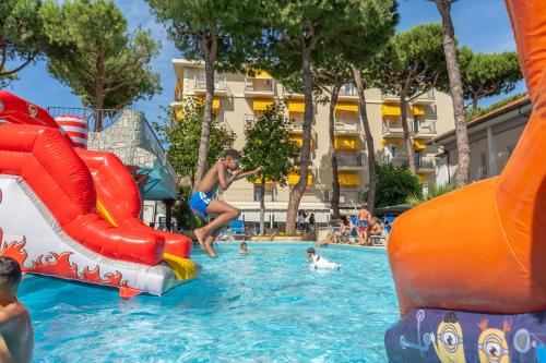 eine Gruppe von Menschen spielt im Wasser eines Resorts in der Unterkunft Hotel Fabrizio in Rimini