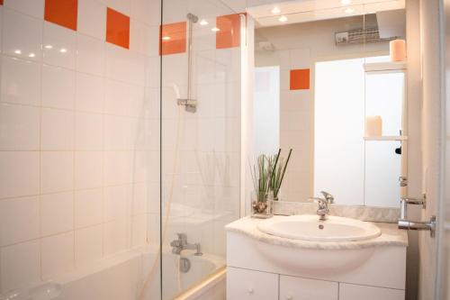 a white bathroom with a sink and a shower at Résidence Vignec Village by Actisource in Vignec