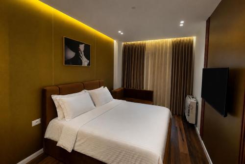 a bedroom with a large white bed with a yellow wall at Dream Luxury Suite in Tirana
