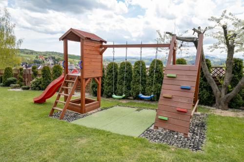 a wooden playground with a ladder and a slide at Willa Pienińska in Kluszkowce