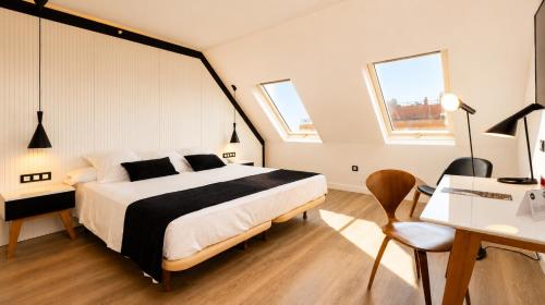 a bedroom with a large bed and a desk and a desk at Vértice Sevilla in Seville