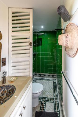 a green tiled bathroom with a toilet and a shower at La Vida Surf - Yoga Villa in Ounara