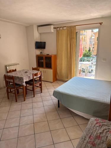 a bedroom with a bed and a table and a window at Villamareblu in Ventimiglia