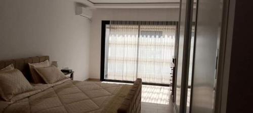 a bedroom with a bed and a large window at Kelibia Jinen EL mansoura in Kelibia