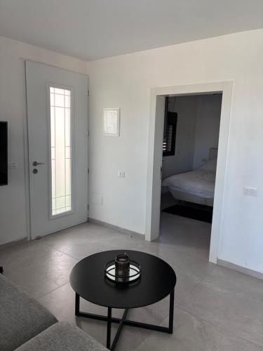 a living room with a coffee table and a bed at Quiet spot in Qiryat Ata