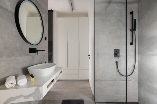 a bathroom with a sink and a shower with a mirror at Residence Maru' in Rovinj