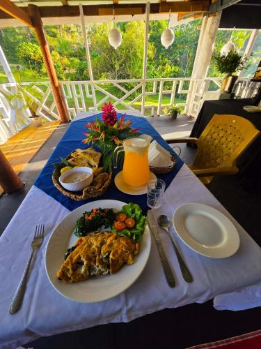ein Tisch mit Tellern voller Essen und einem Glas Orangensaft in der Unterkunft Pula Re Accomodation in Savusavu