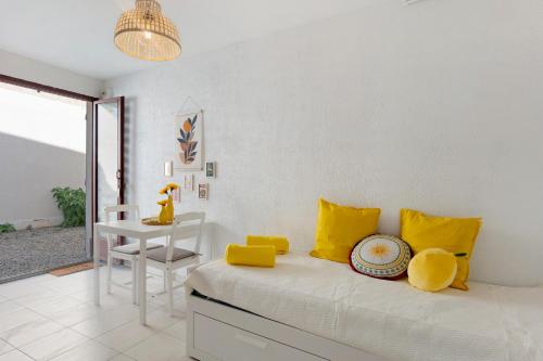 a room with a bed with yellow pillows and a table at O Sole Mio Zen Haven in Valras-Plage