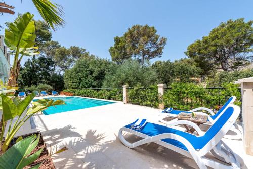 a swimming pool with two lounge chairs next to a swimming pool at Casa Gotmar 132 in El Port