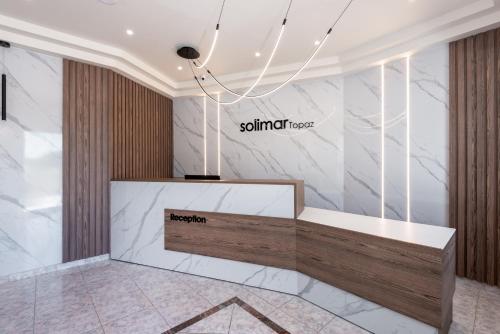 a lobby with a reception desk and marble walls at Solimar Topaz - Adults Only in Tavronitis