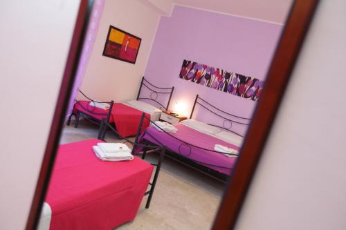 a reflection of a room with two beds and a table at L'attico affittacamere B&B in Catanzaro