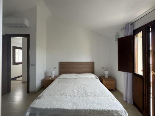 a bedroom with a large bed and two windows at Casa Giulia in Palau
