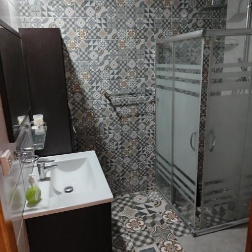 a bathroom with a sink and a glass shower at Kelibia Jinen EL mansoura in Kelibia