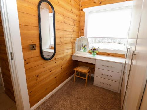 a bathroom with a sink and a mirror at Bulrush Cabin in Carlisle
