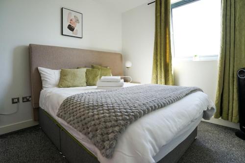 a bedroom with a large bed and a window at Stylish 2-Bed Apartment, Free Parking, Walk to Hospital & Uni in Sheffield