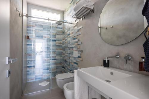 a bathroom with a sink and a toilet and a mirror at Villa Argentea in Ragusa