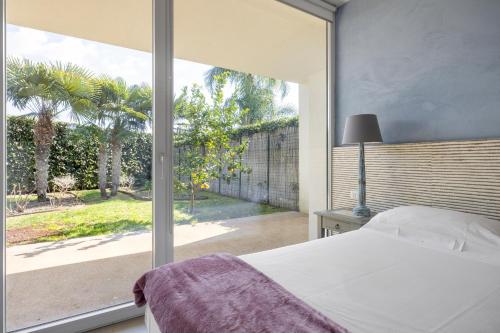 a bedroom with a bed and a large window at Villa Argentea in Ragusa