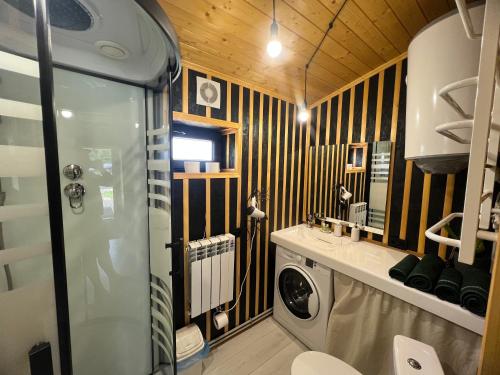 a bathroom with a washing machine in a room at Fazenda Fishbone, будиночок White fish in Verkhovyna