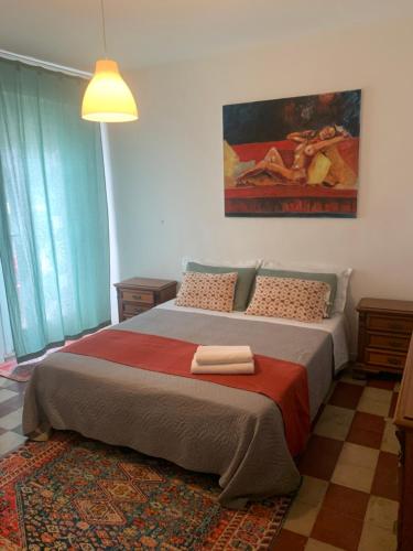 a bedroom with a large bed with a painting on the wall at Hotel Migani in Rimini