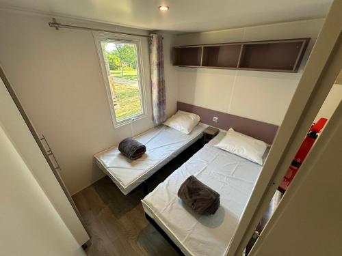 two beds in a small room with a window at l echo du canigou in Sahorre