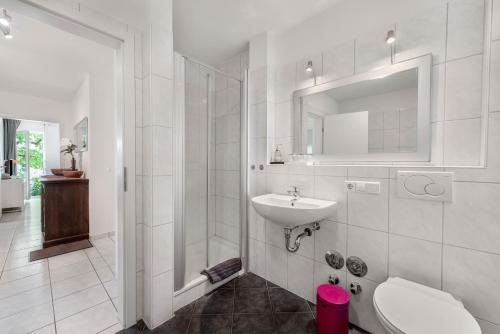 a white bathroom with a sink and a mirror at Ferienwohnung Annabelle in Bodman-Ludwigshafen