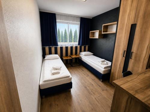 a small room with two beds and a window at B&B Gdynia in Gdynia