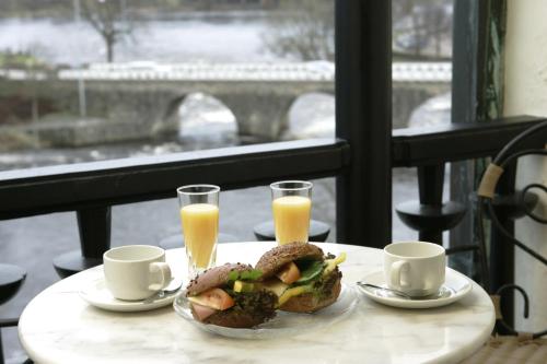 uma mesa com uma sanduíche e dois copos de sumo de laranja em Grand Hotel Falkenberg em Falkenberg